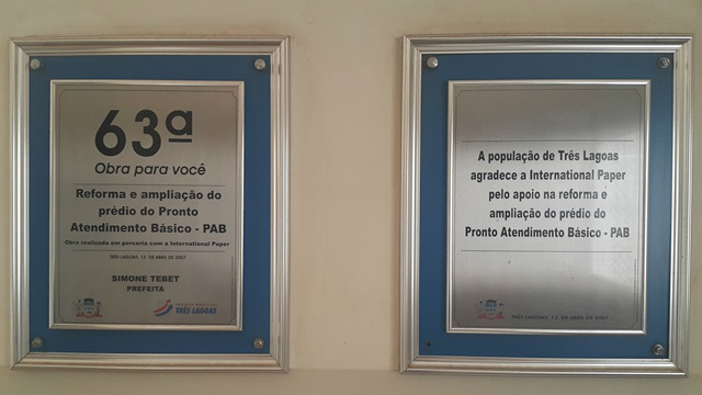 Placas comemorativas fixadas na recepção abandonada sendo uma em comemoração à entrega do prédio e outra de agradecimento por um dos patrocinadores.
