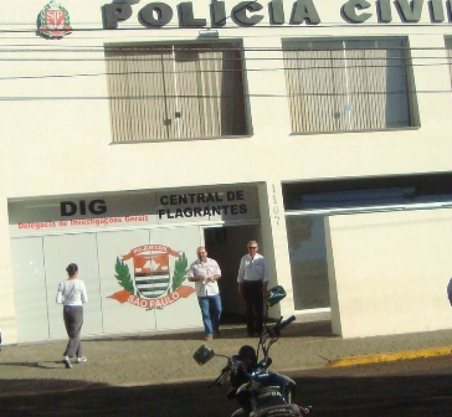 Momento em que a vítima, de costas, chega à delegacia para falar com o delegado Marcelo Curi (de calça jeans)
