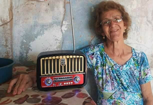 Dona Rosa e o radinho companheiro de manhãs de cozinha e tardes de lavar roupa pela casa. (Foto: Arquivo Pessoal)