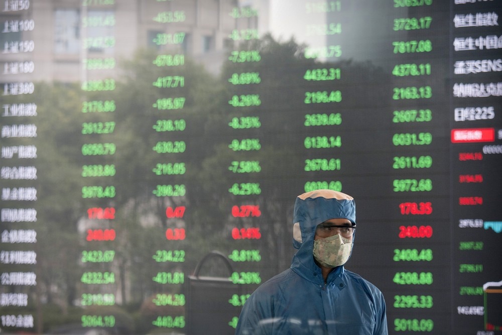 Operador da bolsa de Xangai trabalha com máscara na abertura do mercado chinês, nesta segunda-feira (3). Foto: AP Photo.