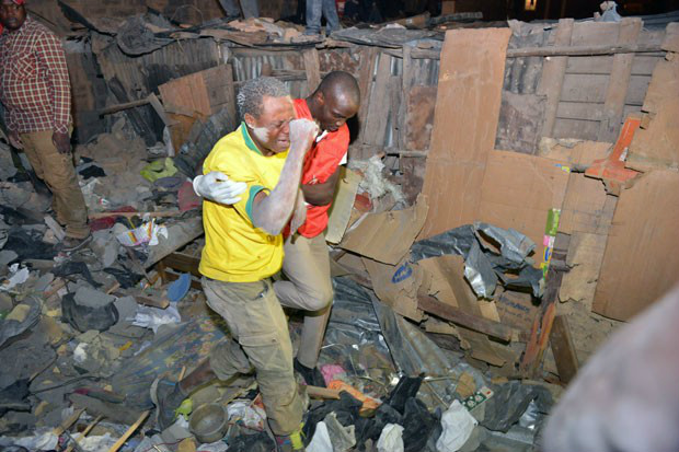 Vestindo uma camisa da seleção brasileira, voluntário das buscas chora em desespero enquanto tenta encontrar sua mulher, que desapareceu após o colapso do prédio residencial em Nairobi (Foto: Tony Karumba/AFP)