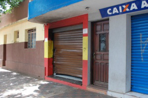 Ladrões invadiram a loja, de cor vermelha, levaram objetos e ainda atearam fogo no local. (Foto: Alan Diógenes)