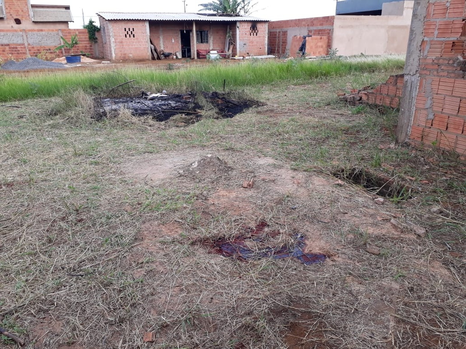 Fogo em amontado de lixo e sangue na grama em MS — Foto: Osvaldo Nóbrega/TV Morena
