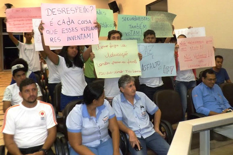 Alunos mostram cartazes com frases direcionadas aos vereadores