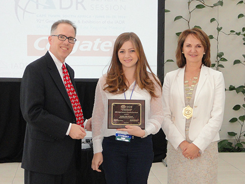 A doutoranda Jackeline do Amaral (centro) recebe placa entregue por Marck Morrison e Helen Whelton