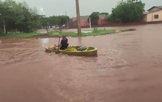 Morador andando de caiaque em avenida alagada de Rio Brilhante (Foto: reprodução / vídeo)