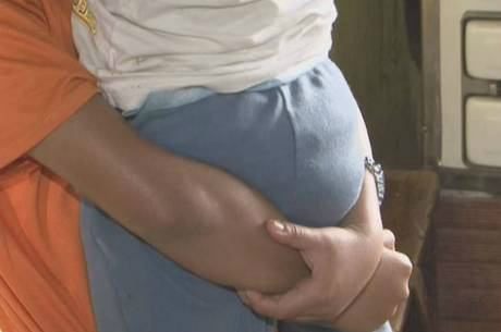 Jovem segura nos braços um dos filhos que teve com o próprio paiReprodução Rede Record