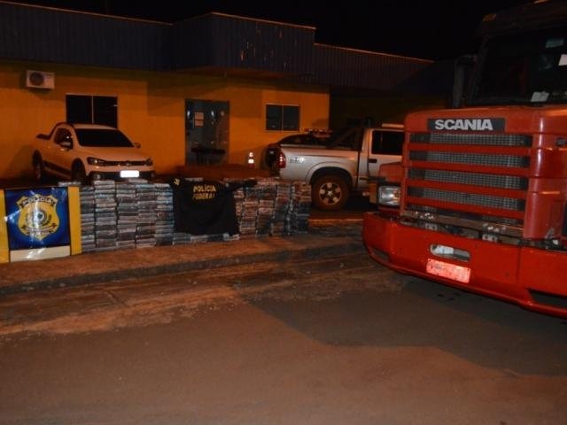 Tabletes de cocaína em frente ao caminhão que era usado para transportar a droga (Foto: Divulgação)