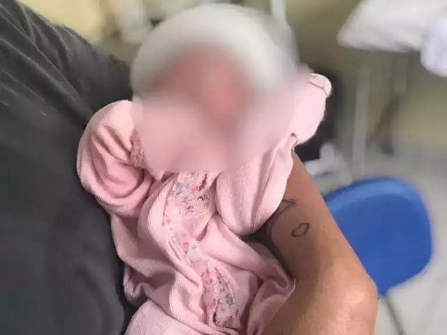 Bebê durante atendimento médico no colo de Kely, na sexta-feira (29). (Foto: Arquivo pessoal)
