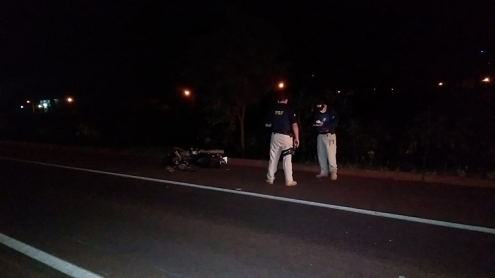 Policiais que atenderam a ocorrência e a moto da vítima — Foto: Adílson Domingos