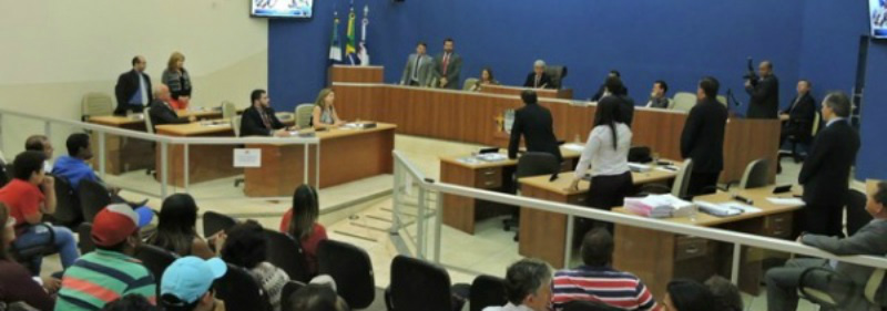 Vereadores que votaram a favor da criação da CP estão de pé. Da esquerda para a direita: No fundo de pé: 1. Ivanildo e 2. Mariza, perto das bandeiras 3. Welton Irmão,  4. Bazé, no plenário de costa: 5. Gilmar, 6. Idevaldo (encoberto), 7. Sirlene, 8. Gil do Jupiá e 9. Beto.
