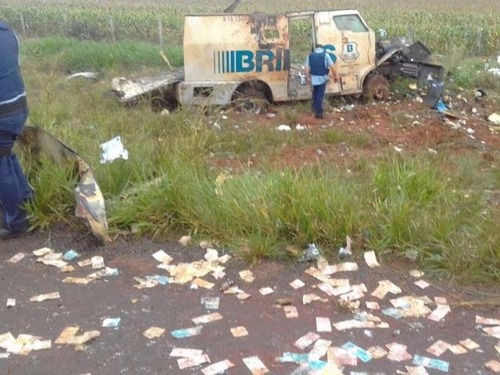 Carro-forte destruído por explosivos e dinheiro espalhado na estrada após ataque na manhã de hoje (Foto: Direto das Ruas)
