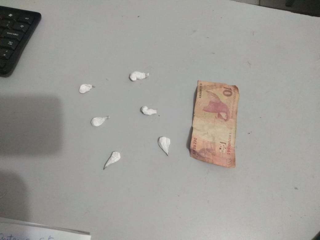 Porções de cocaína e uma nota de 10 reais, apreendidos com o rapaz. Foto: Divulgação da Polícia Militar