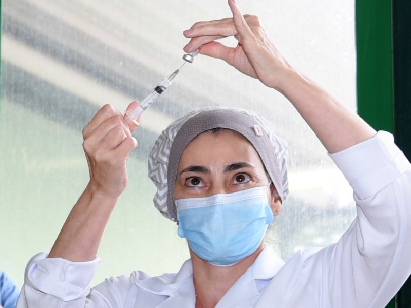Profissional da saúde prepara dose da vacina para aplicação.