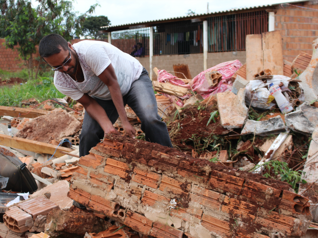 Gilson remove escombros para tentar encontrar pertences (Foto: Ricardo Campos Jr./ G1 MS)