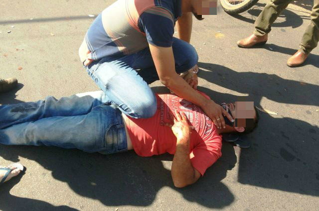 Vítima sendo socorrida por um popular que tentava estancar o sangue até a chegada dos Bombeiros.