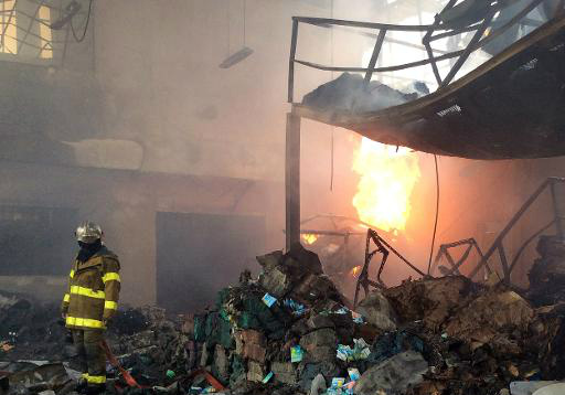 Bombeiros no depósito onde a bomba explodiu. Foto: AFP Photo