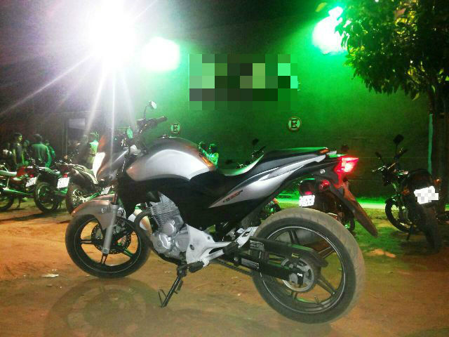 Moto Honda CB 300 de cor prata estacionada em frente a um clube é apreendida pela ROTAI.