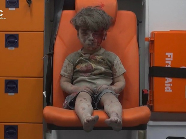 Menino foi resgatado com vida sob os escombros de edifício após bombardeio em Aleppo (Foto: Aleppo Media Center/AP)