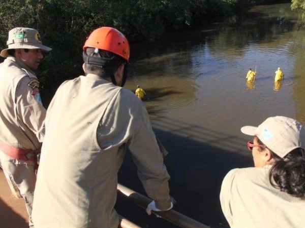 Bombeiros e policiais militares no rio Anhanduí na manhã deste sábado (22) (Foto: Marcos Ermínio)