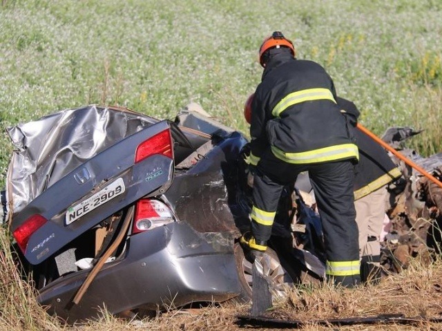 Bombeiro trabalhando na retirada dos corpos, presos às ferragens (Foto: Norbertino Angeli/Jovem Sul News)