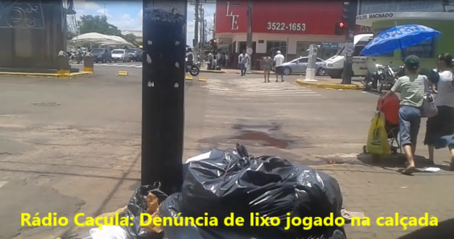 Sob um forte sol predominante. sras. com crianças e adultos são obrigados a desviar do lixo.