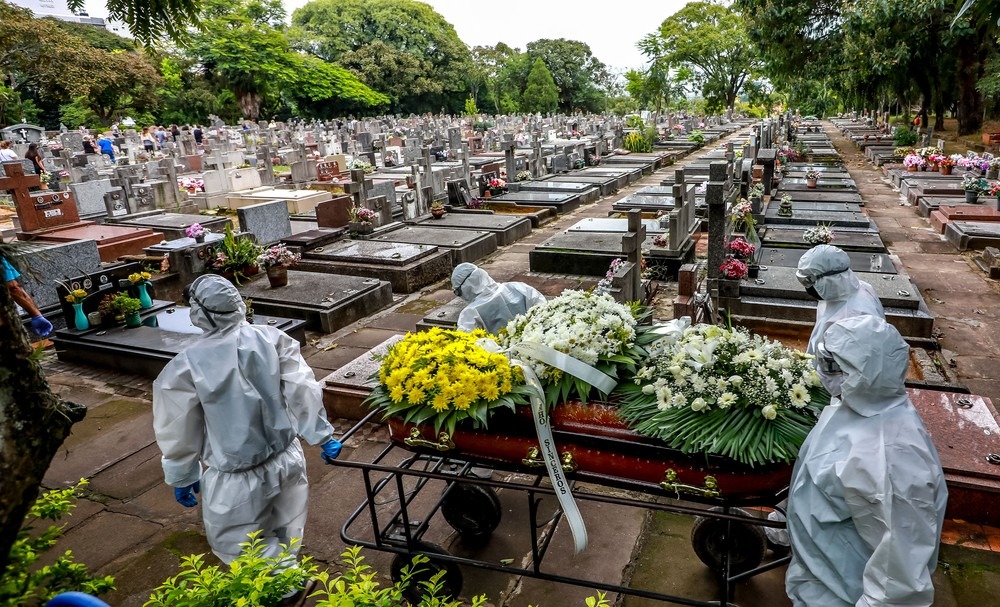 Coveiros carregam caixão de vítima da Covid-19 em cemitério municipal — Foto: Silvio Avila/AFP