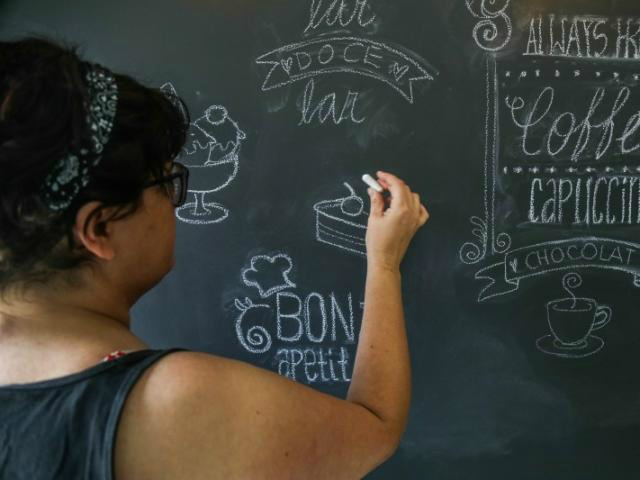 Mineira voltou a Campo Grande para visitar família, e na casa do irmão, desenha em lousa. (Foto: Fernando Antunes)
