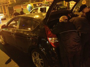 Policiais realizavam perícia no carro por volta das21h30 (Foto: Gabriel Barreira / G1)