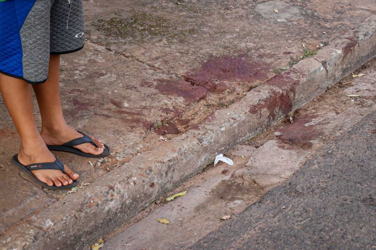 Criança, de 9 anos, ao lado de manchas de sangue provocadas por ataque (Foto: Henrique Kawaminami)