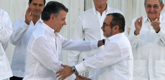 Presidente da Colômbia e o líder das Farc apertam as mãos após assinatura do acordo de paz.