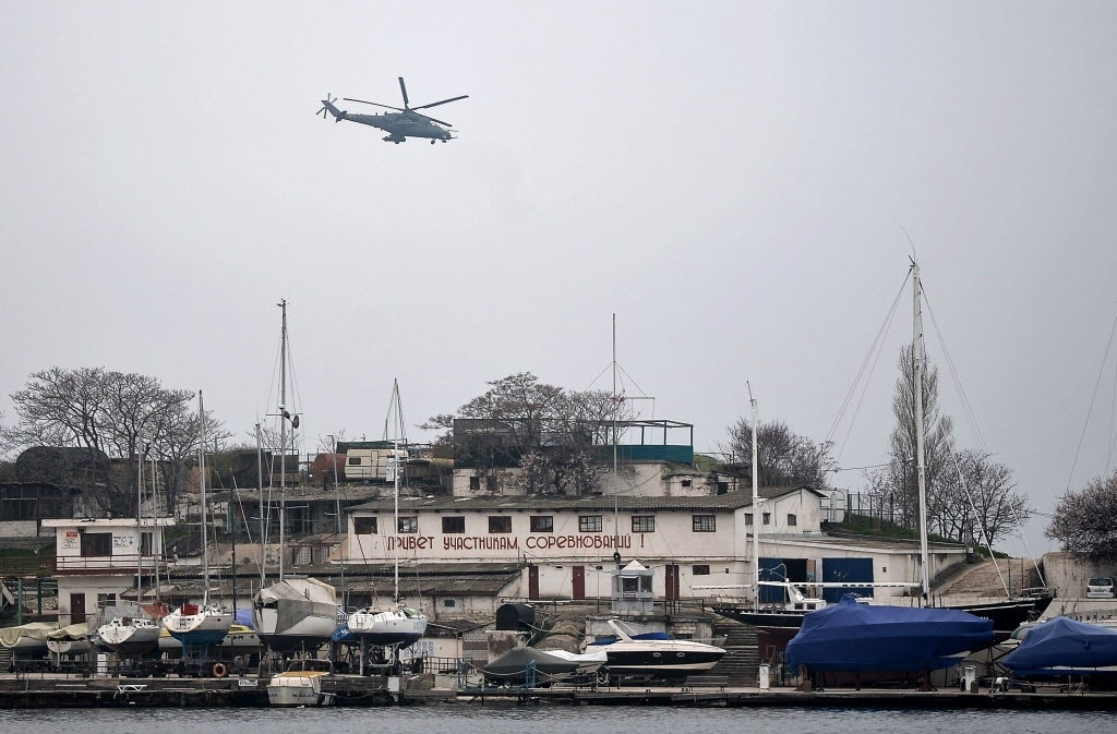 Helicóptero militar russo sobrevoa porto de Sebastopolno começo de Março (Foto: AFP)