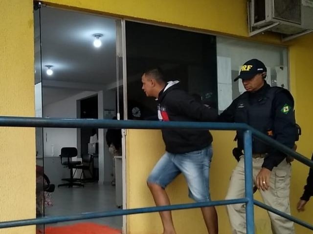 Um dos presos na operação desta sexta (2) é conduzido à delegacia da PRF na BR-163 (Foto: Adilson Domingos)