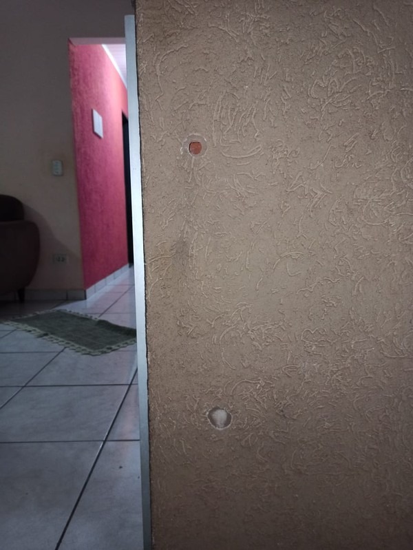 Na parede da casa da vítima ficaram as marcas de tiros — Foto: Polícia Civil/Divulgação
