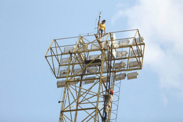 Mulher fica no topo da torre de iluminação do Estádio Morenão (Foto: Marcelo Victor)