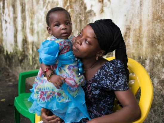 Nubia com a tia que cuida dela, Mabinty Soumah (Foto: Albert Masias/MSF)