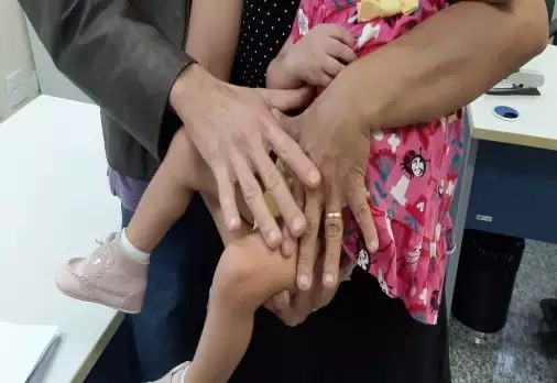 No colo dos pais, com quem agora passará a conviver (Foto: Divulgação/TJMS)