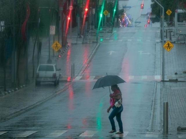 Chuva e tempo escuro teimando em deixar dia amanhecer fizeram neon com as luzes da Rua 14 de Julho (Foto: Henrique Kawaminami)