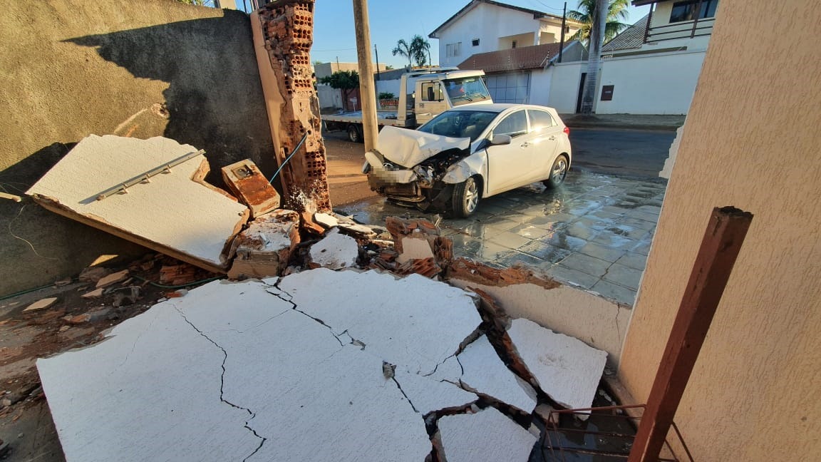 O motorista do veículo HB 20 de cor branca invadiu um muro de residência, causando prejuízos e fugiu do local. Foto: Fábio Campos/Rádio Caçula.