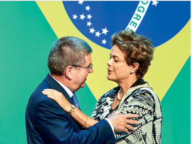 OUTROS TEMPOS - Dilma cumprimenta Thomas Bach, presidente do COI: será que ela vai à cerimônia da tocha na Grécia?(Julio Cesar Guimarães/Folhapress)