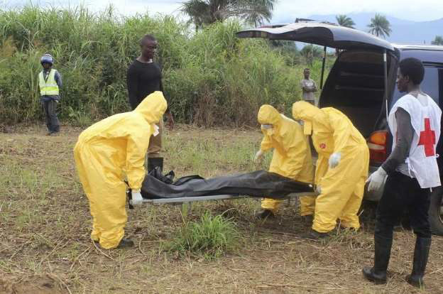 © REUTERS/Josephus Olu-Mamma Agentes carregam corpo de vítima do Ebola em Serra Leoa. Foto de 21/10/2014.