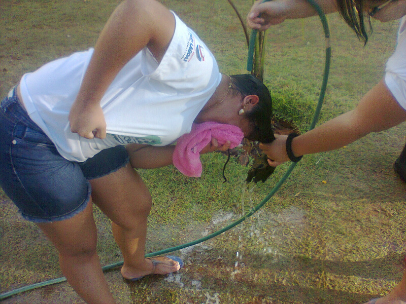 Professora lava cabelo de aluna com mangueira por falta de estrutura.]Foto: Rádio Caçula. 